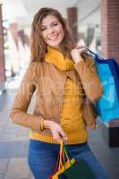 Portrait of smiling woman with shopping bags looking at camera