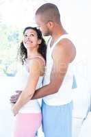 Side view of happy pregnant wife with husband touching belly