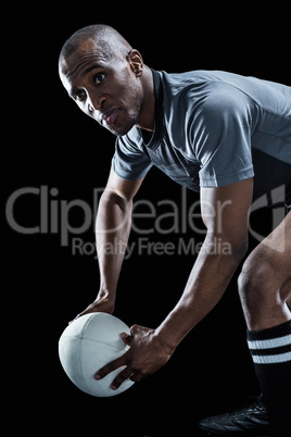 Rugby player looking away while holding ball