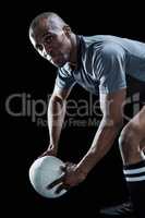 Rugby player looking away while holding ball