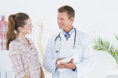 Happy doctor with clipboard talking to patient