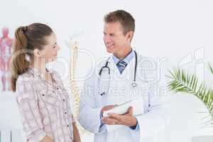 Happy doctor with clipboard talking to patient