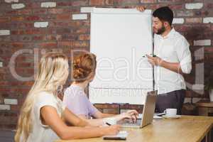 Businessman briefing over whiteboard to colleagues