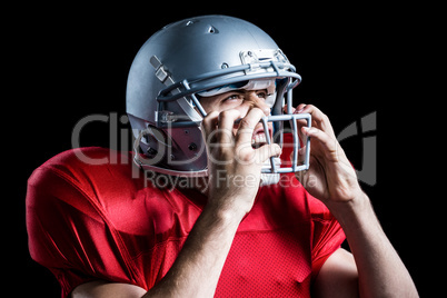 Aggressive American football player holding helmet