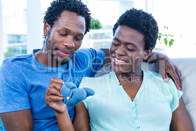 Husband and wife looking at baby shoe while sitting