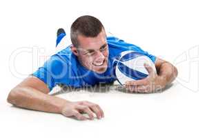Confident rugby player lying in front with ball