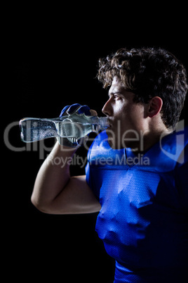 Side view of sportsman drinking water