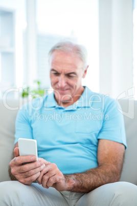 Senior man using smartphone at home Senior man using smartphone at home