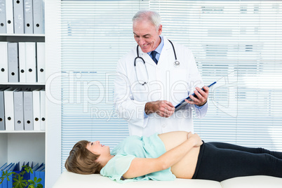 Doctor looking at pregnant woman at clinic