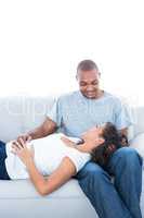 Pregnant woman lying on sofa with husband