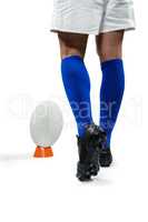Low section of rugby player going to kick the ball