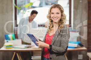 Portrait of woman working on digital tablet in office