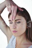 Woman meditating with hand on forehead