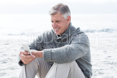 Smiling man sitting and on his phone