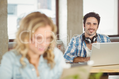 Portrait of smiling handsome business man using laptop in office