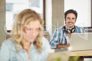 Portrait of smiling handsome business man using laptop in office