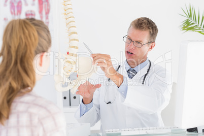 Doctor showing his patient a spine model