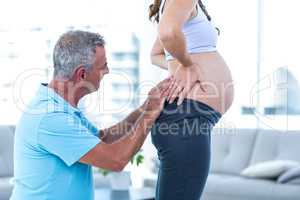Therapist massaging pregnant woman at home