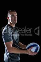 Rugby player looking way while holding ball