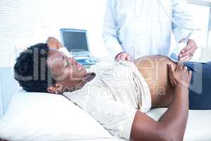 Doctor using ultrasound machine on pregnant woman