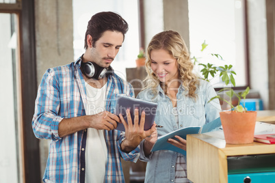 Businessman showing digital tablet to colleague in office