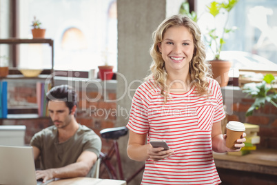 Portrait of smiling businesswoman using smartphone while holding Portrait of smiling businesswoman using smartphone while holding
