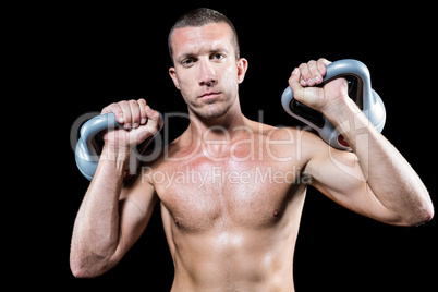 Confident shirtless athlete holding kettlebell