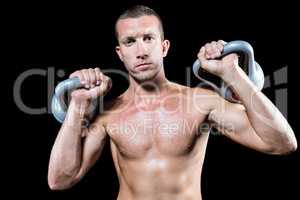 Confident shirtless athlete holding kettlebell
