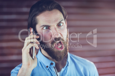 Hipster making a face while talking on cellphone