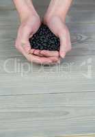 Woman showing handful of black beans