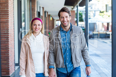 Smiling couple with shopping bags holding hands