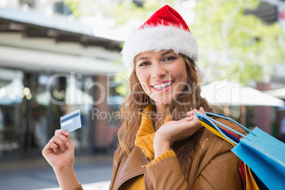 Portrait of smiling woman with santa hat and shopping bags