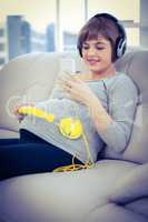 Pregnant woman using smartphone while listening to music