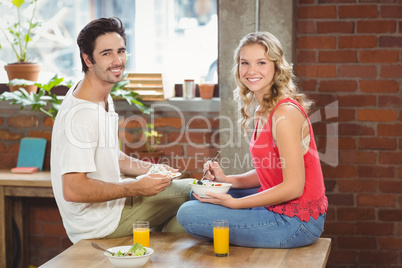 Portrait of happy colleague having meal in office