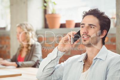 Businessman talking over phone in office