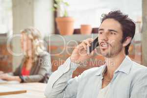 Businessman talking over phone in office