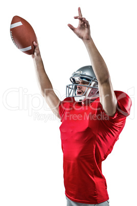 American football player holding ball while pointing up