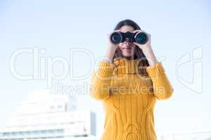 Beautiful woman looking through binoculars