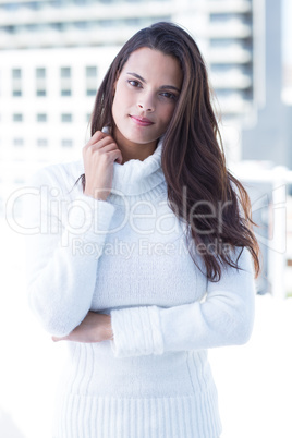 Thoughtful woman looking at camera with hand on collar