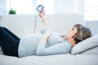 Beautiful pregnant woman looking at sonogram