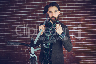 Portrait of confident man with bicycle smoking pipe