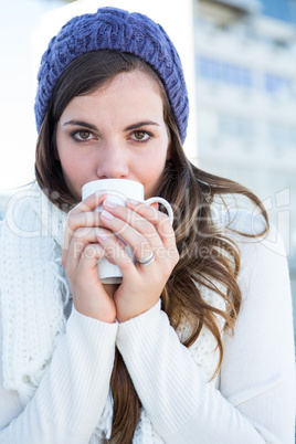 Brunette with warm clothes drinking coffee