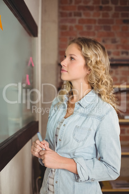 Businesswoman holding marker in creative office