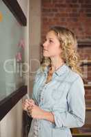 Businesswoman holding marker in creative office