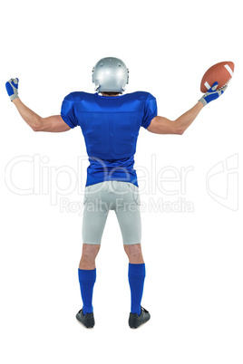 Full length rear view of American football player holding ball