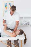 Doctor stretching a young woman back