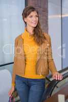 Smiling woman standing next to escalator