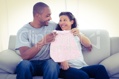 Cheerful couple with baby clothing