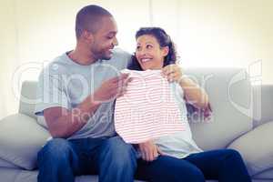 Cheerful couple with baby clothing