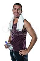 Smiling man with towel on neck holding water bottle